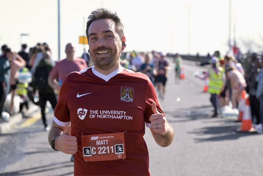 Me running the Southampton 10K. I am smiling and giving a thumbs up.